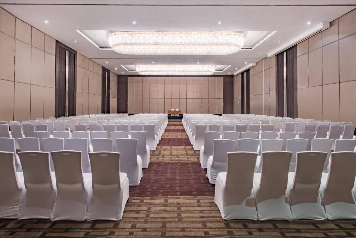 an empty banquet hall with white chairs and tables at Crowne Plaza Kochi by IHG in Cochin