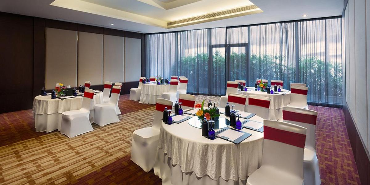 a conference room with white tables and white chairs at Crowne Plaza Kochi by IHG in Cochin