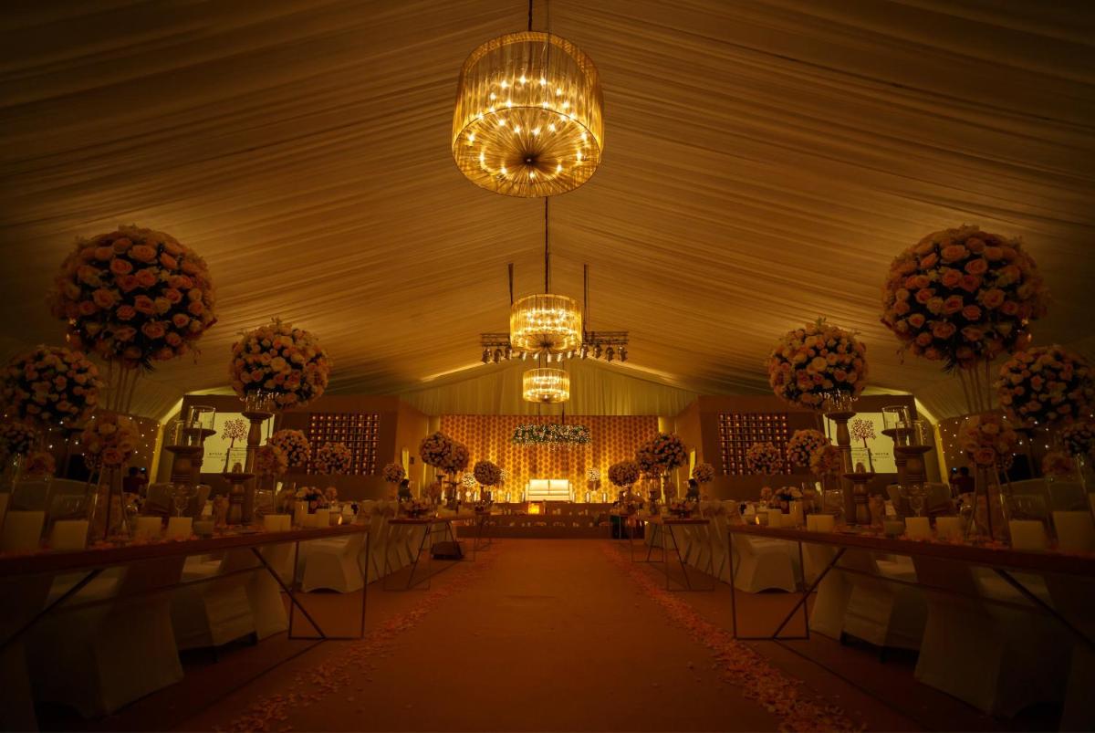 a banquet hall with tables and chandeliers at Crowne Plaza Kochi by IHG in Cochin
