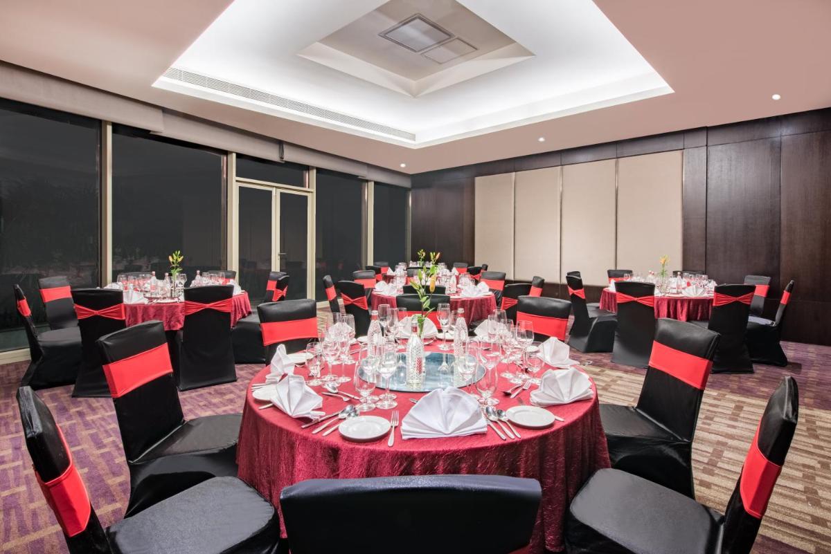 a conference room with red tables and chairs at Crowne Plaza Kochi by IHG in Cochin