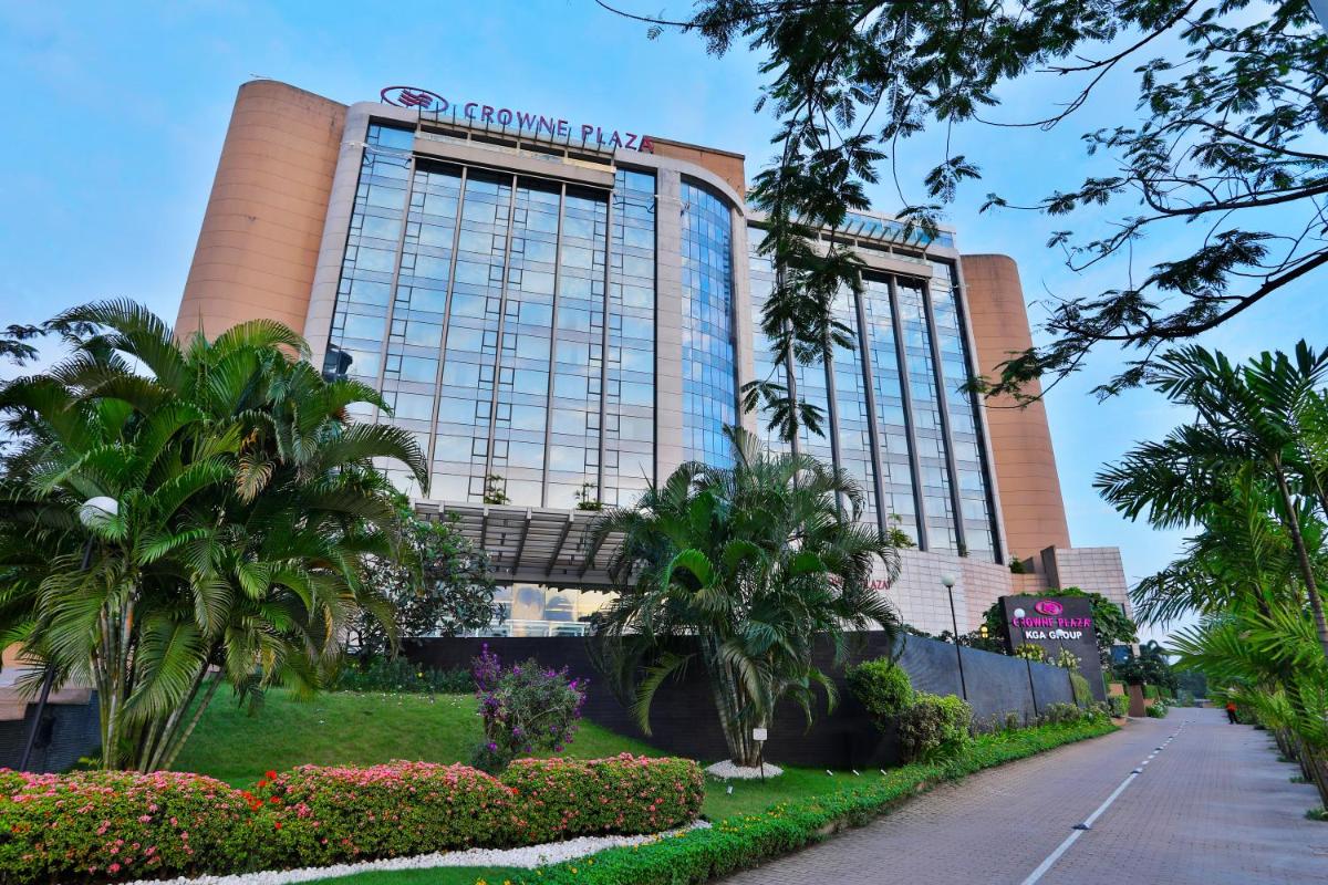 a hotel building with palm trees in front of it at Crowne Plaza Kochi by IHG in Cochin