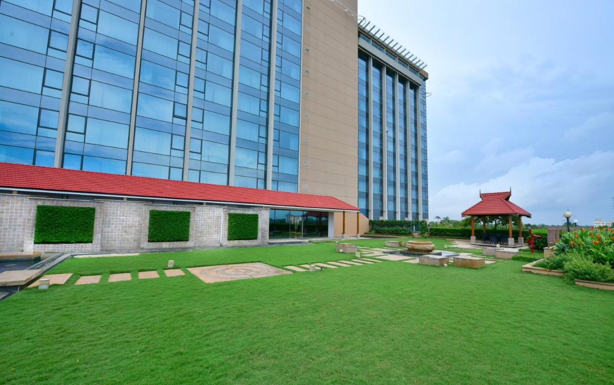 a large building with a lawn in front of it at Crowne Plaza Kochi by IHG in Cochin