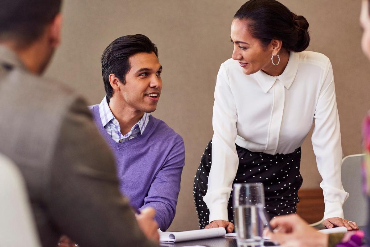a man and woman sitting at a table in a meeting at Crowne Plaza Kochi by IHG in Cochin