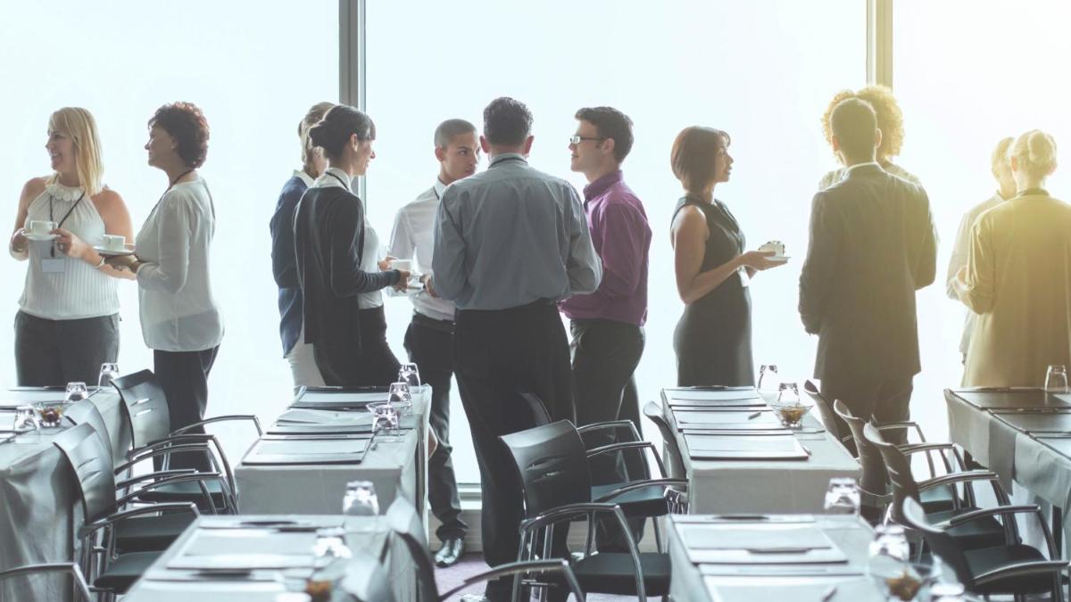 a group of people standing around tables in a room at Crowne Plaza Kochi by IHG in Cochin