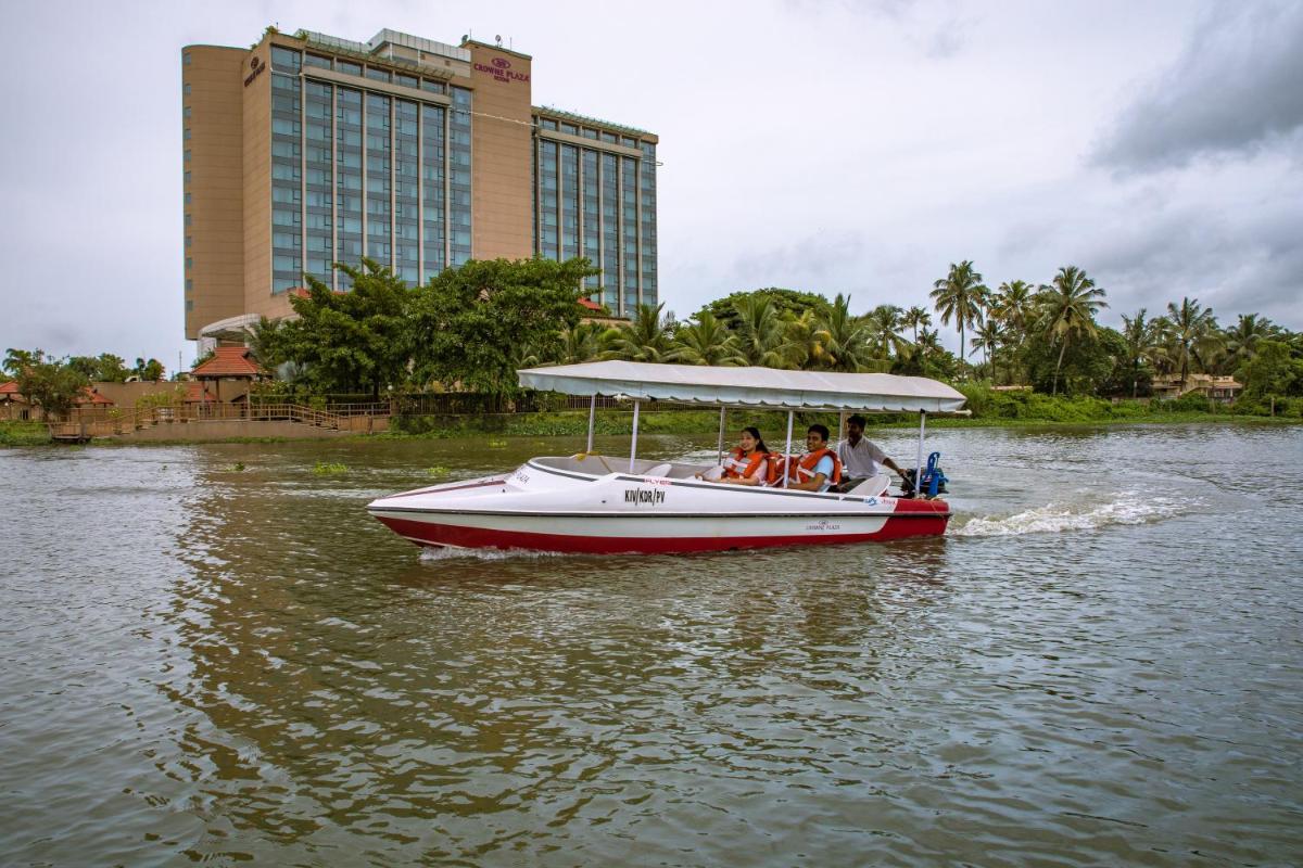 a group of people on a boat in the water at Crowne Plaza Kochi by IHG in Cochin