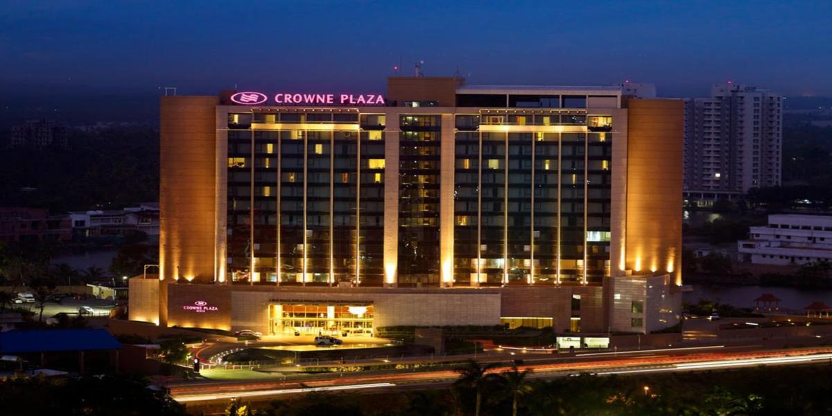 a building with a sign on top of it at night at Crowne Plaza Kochi by IHG in Cochin