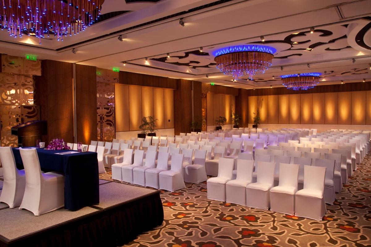 a banquet hall with white chairs and tables and chandeliers at Crowne Plaza New Delhi Okhla by IHG in New Delhi +96 photos