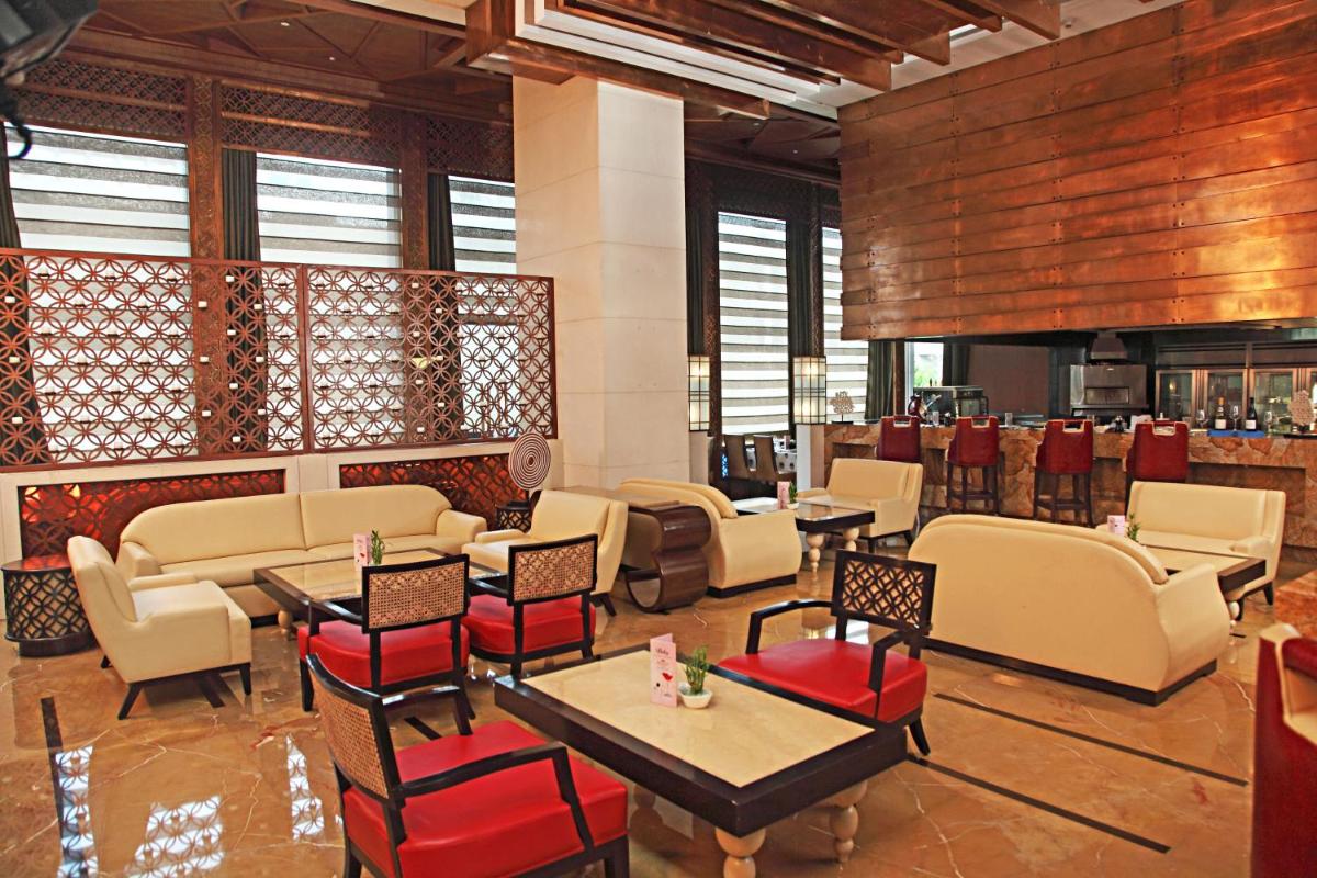 a restaurant with tables and chairs and a bar at Crowne Plaza New Delhi Okhla by IHG in New Delhi