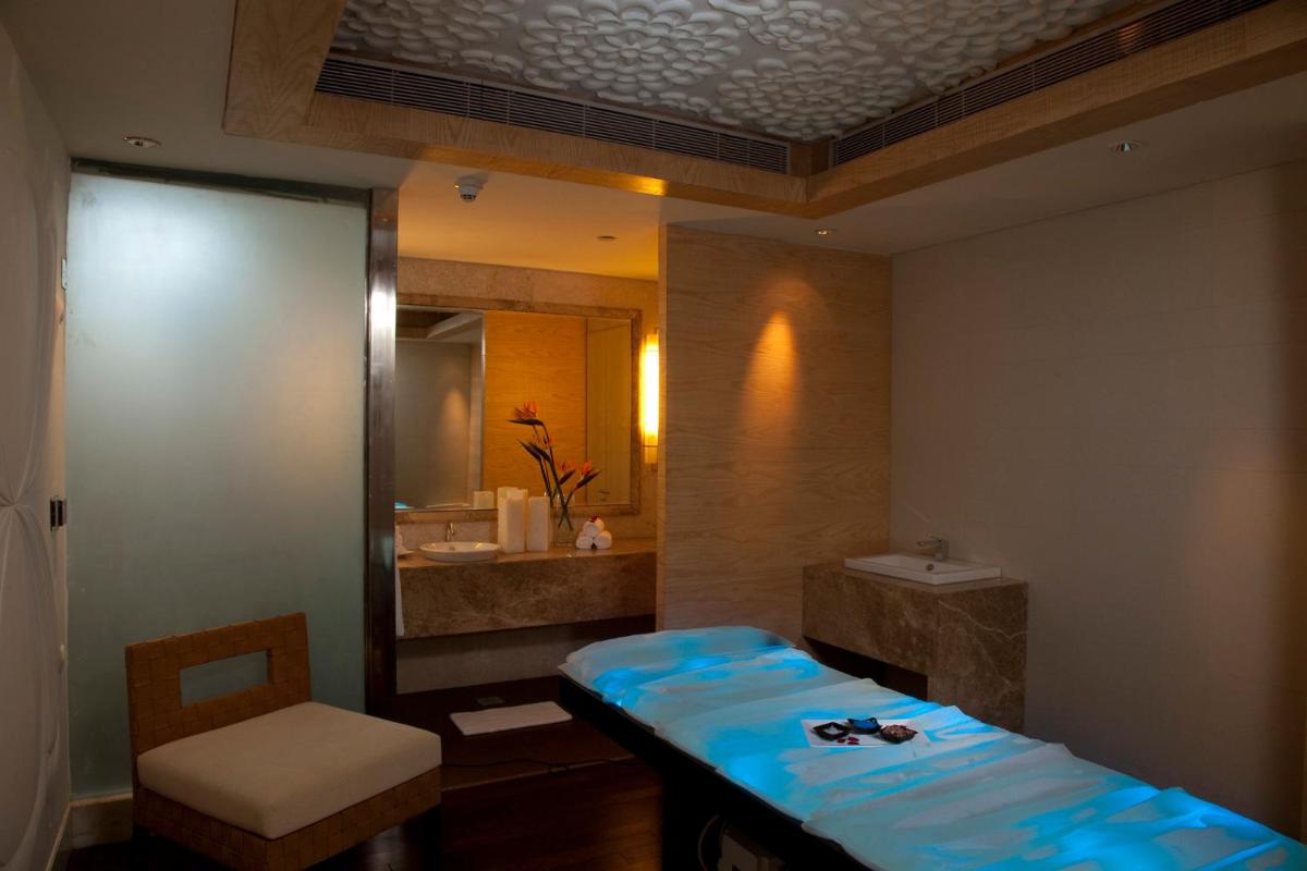 a bathroom with a bed and a sink and a mirror at Crowne Plaza New Delhi Okhla by IHG in New Delhi