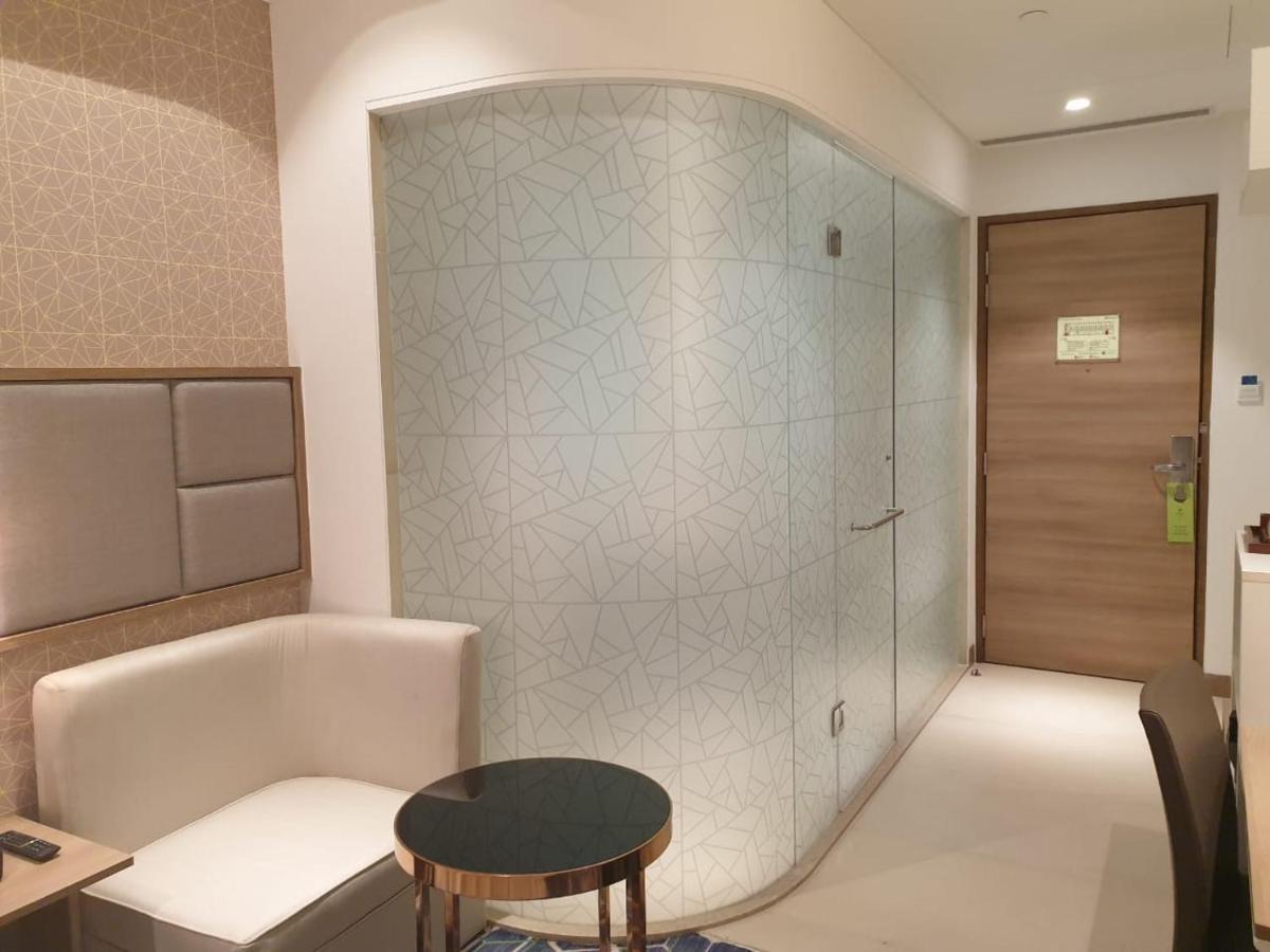a bathroom with a tub and a table and a stool at Holiday Inn Gurugram Sector 90 by IHG in Gurgaon