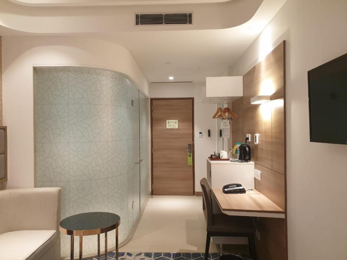 a living room with a table and a kitchen at Holiday Inn Gurugram Sector 90 by IHG in Gurgaon