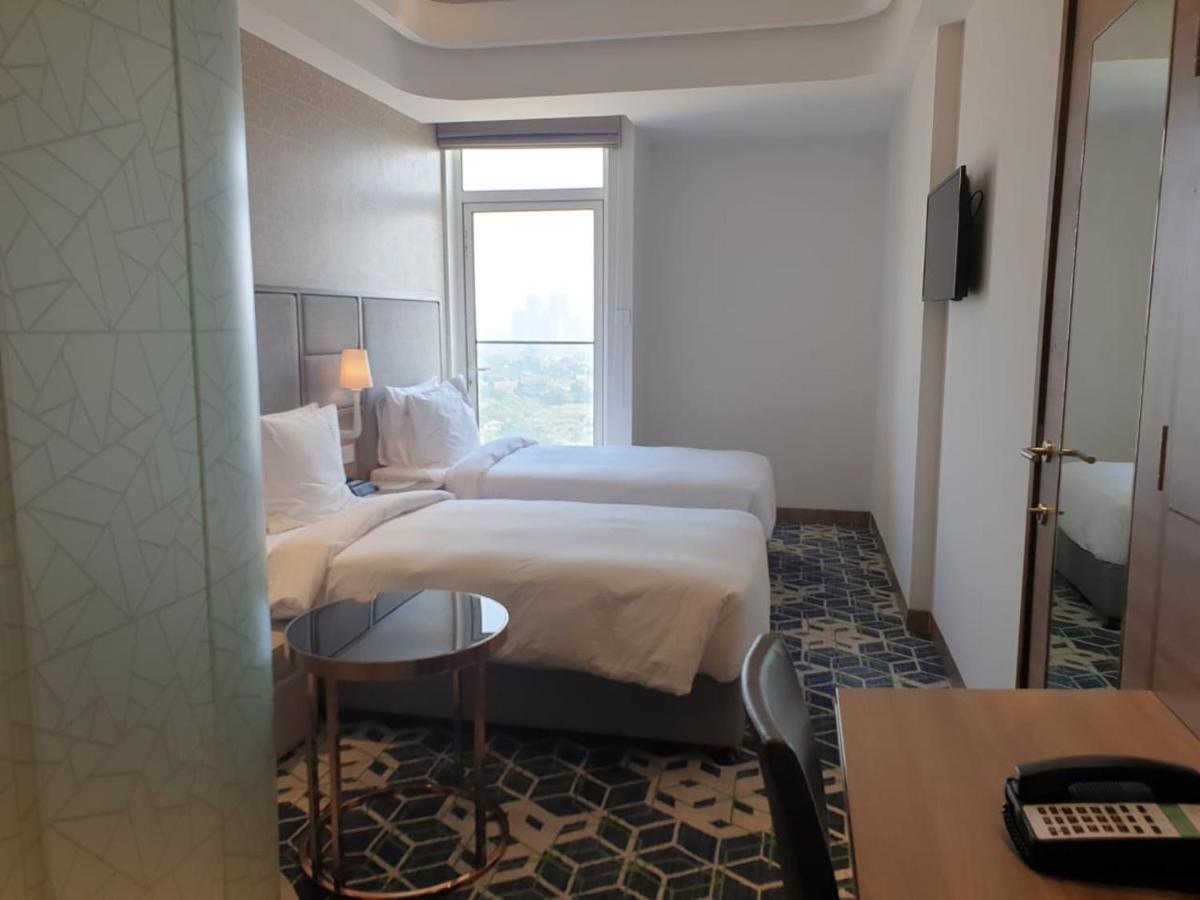 a hotel room with two beds and a window at Holiday Inn Gurugram Sector 90 by IHG in Gurgaon