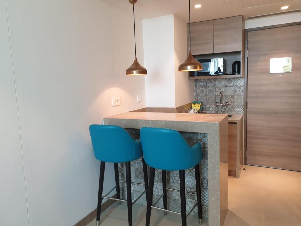 a kitchen with blue bar stools at a counter at Holiday Inn Gurugram Sector 90 by IHG in Gurgaon