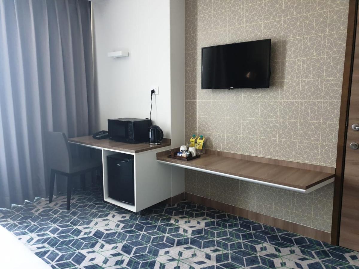 a hotel room with a desk with a television on the wall at Holiday Inn Gurugram Sector 90 by IHG in Gurgaon