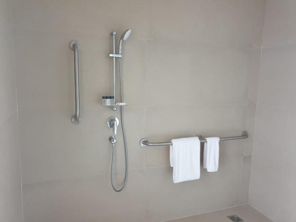a bathroom with a shower with white towels at Holiday Inn Gurugram Sector 90 by IHG in Gurgaon