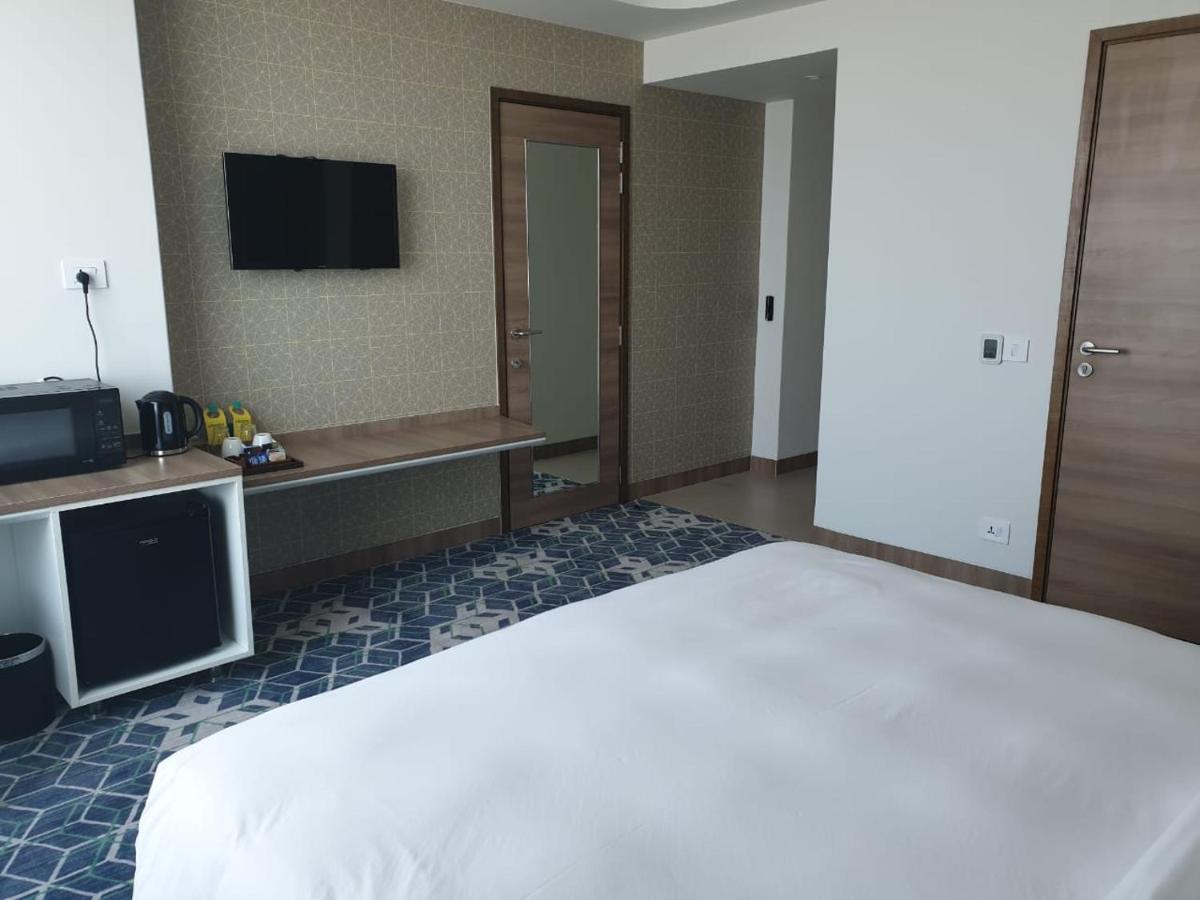 a hotel room with a bed and a television at Holiday Inn Gurugram Sector 90 by IHG in Gurgaon