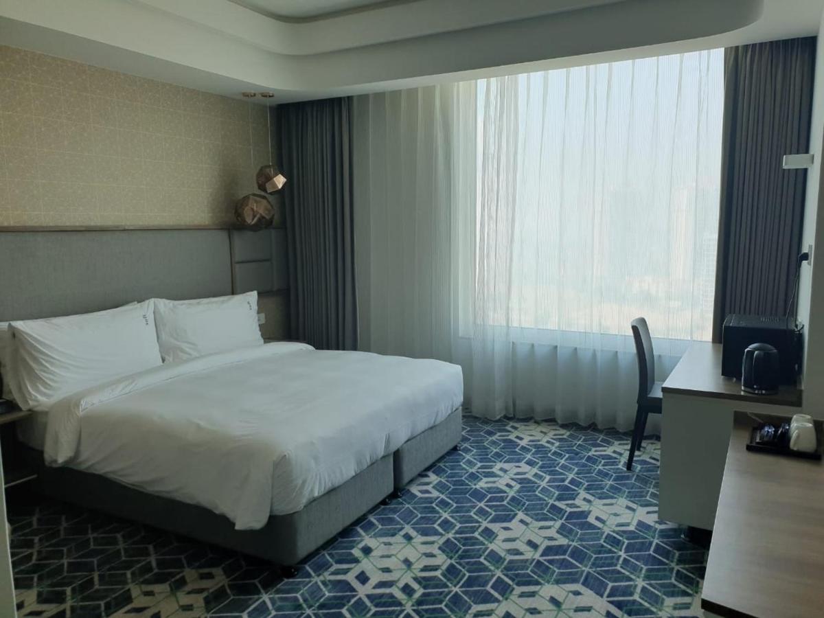 a hotel room with a bed and a window at Holiday Inn Gurugram Sector 90 by IHG in Gurgaon