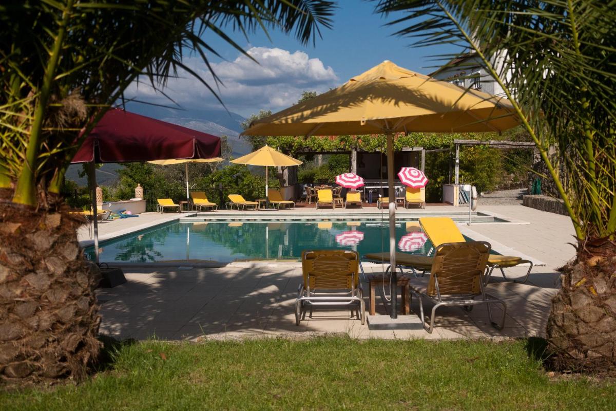 uma piscina com mesa, cadeiras e guarda-sol em Hotel Rural Quinta da Geia em Aldeia das Dez