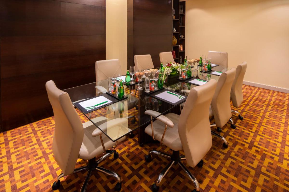 a conference room with a glass table and chairs at Holiday Inn Mumbai International Airport by IHG in Mumbai