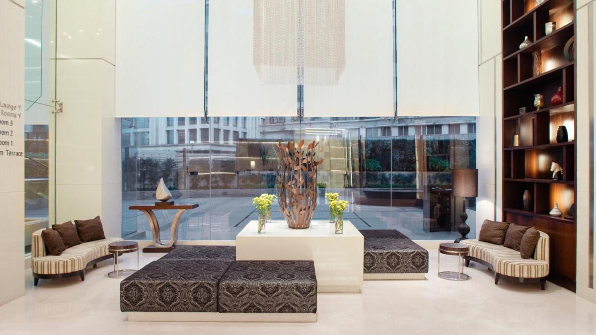 a living room with a vase on a table and chairs at Holiday Inn Mumbai International Airport by IHG in Mumbai
