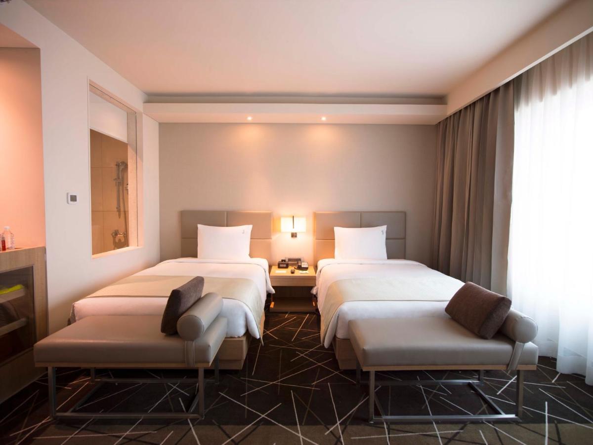 a hotel room with two beds and two chairs at Holiday Inn Chennai OMR IT Expressway by IHG in Chennai
