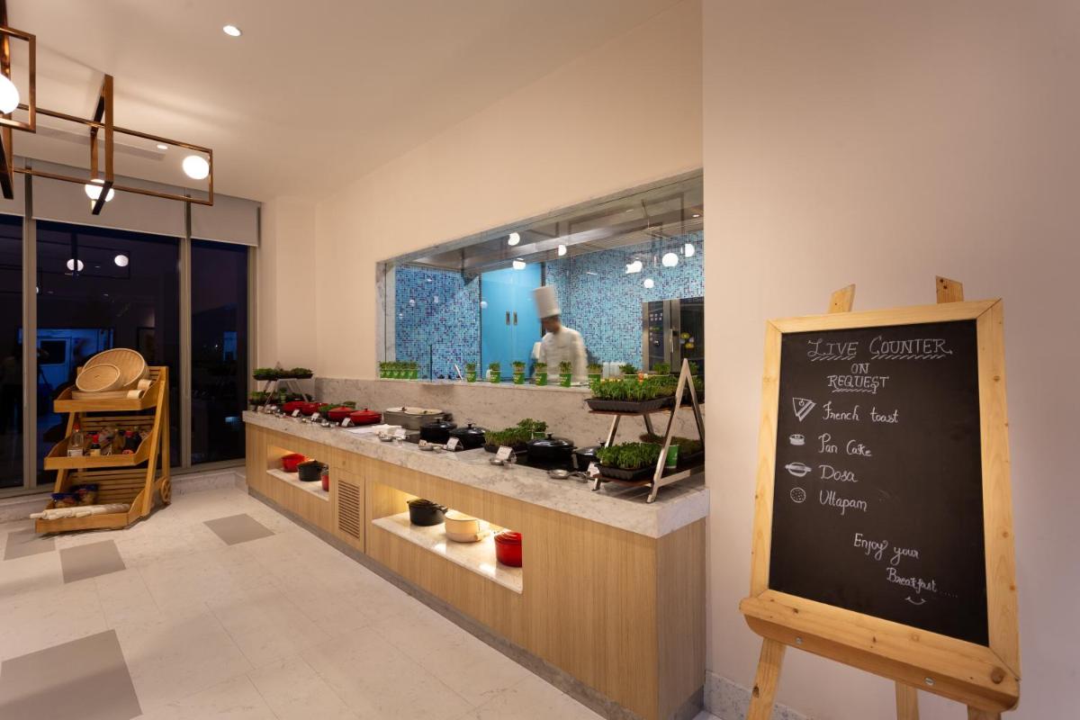 a shop with a chalkboard and a counter with plants at Holiday Inn Bengaluru Racecourse by IHG in Bengaluru a shop with a chalkboard and a counter with plants at Holiday Inn Bengaluru Racecourse by IHG in Bengaluru