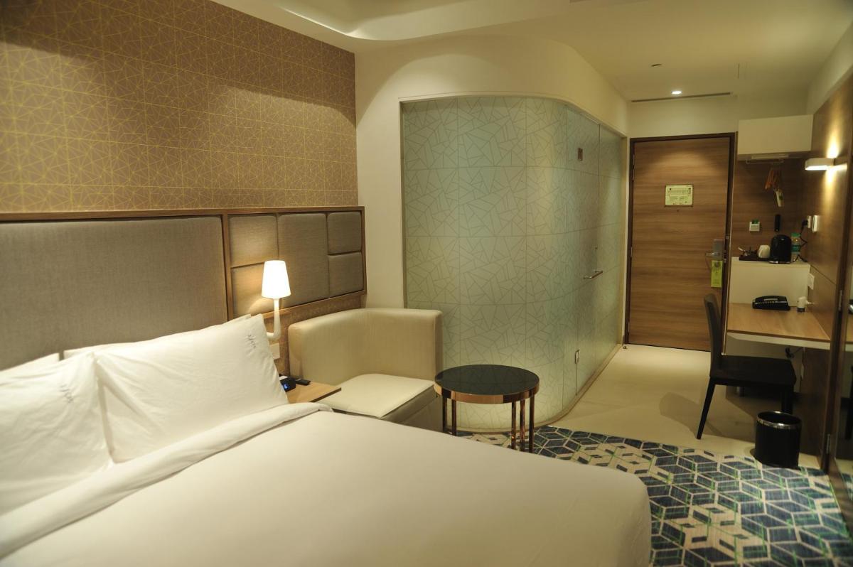 a hotel room with a bed and a desk at Holiday Inn Gurugram Sector 90 by IHG in Gurgaon