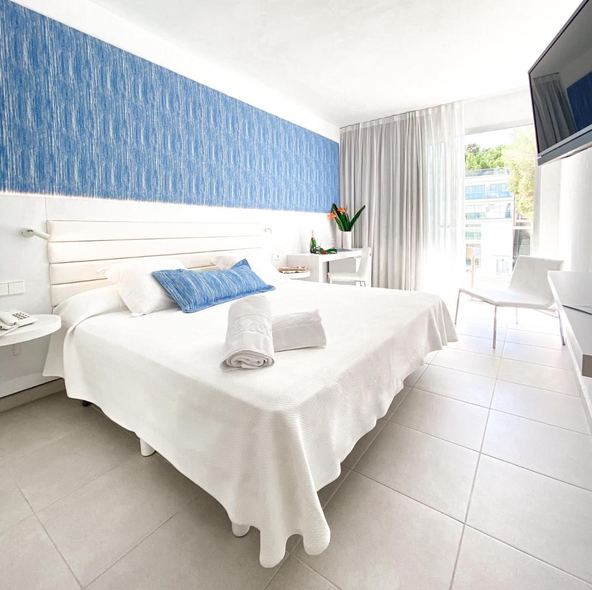 Un dormitorio con una gran cama blanca y una pared azul. en Reverence Life Hotel - Adults Only, en Santa Ponsa 40 fotos más