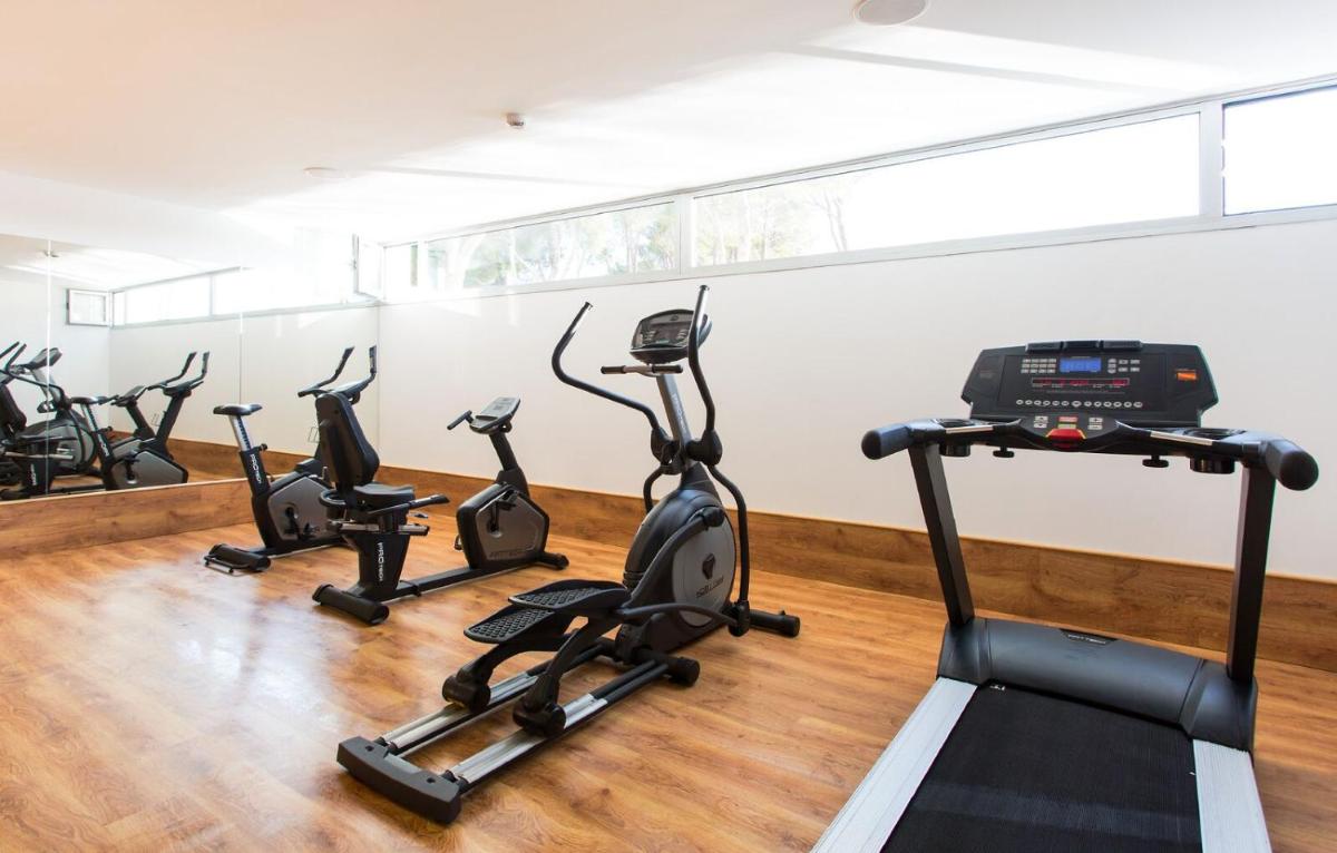 una fila de bicicletas estáticas en un gimnasio en Reverence Life Hotel - Adults Only, en Santa Ponsa