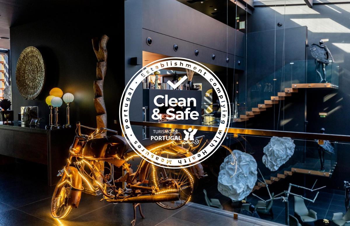 uma placa de uma loja limpa e segura com uma motocicleta em exposição em Evidencia Belverde Hotel em Amora uma placa de uma loja limpa e segura com uma motocicleta em exposição em Evidencia Belverde Hotel em Amora