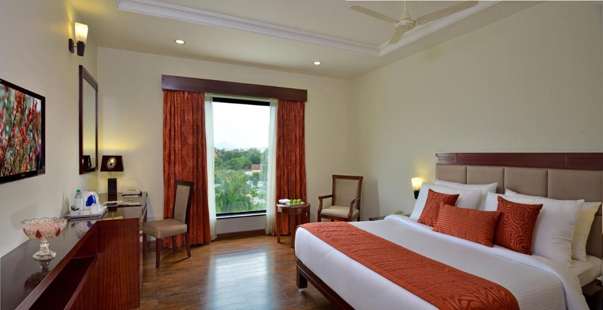 a bedroom with a bed and a desk and a window at Fortune Select Grand Ridge, Tirupati - Member ITC Hotels' Group in Tirupati
