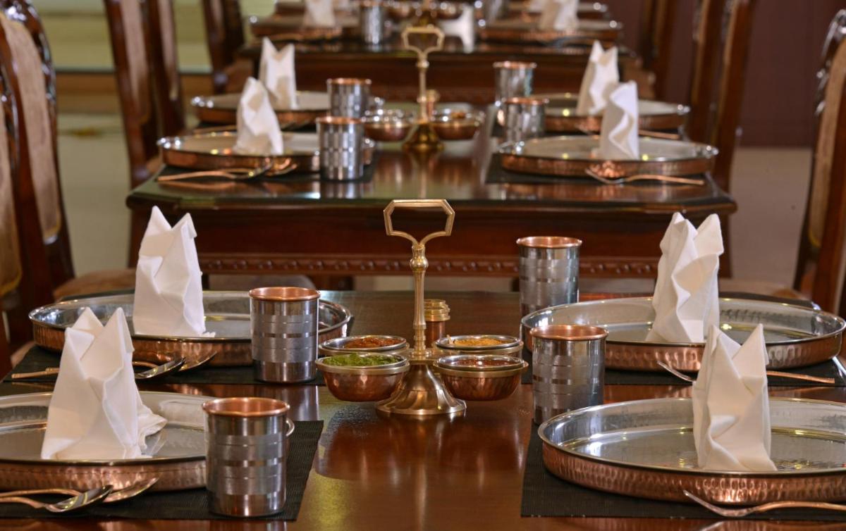 a table with silver plates and napkins on it at Fortune Select Grand Ridge, Tirupati - Member ITC Hotels' Group in Tirupati