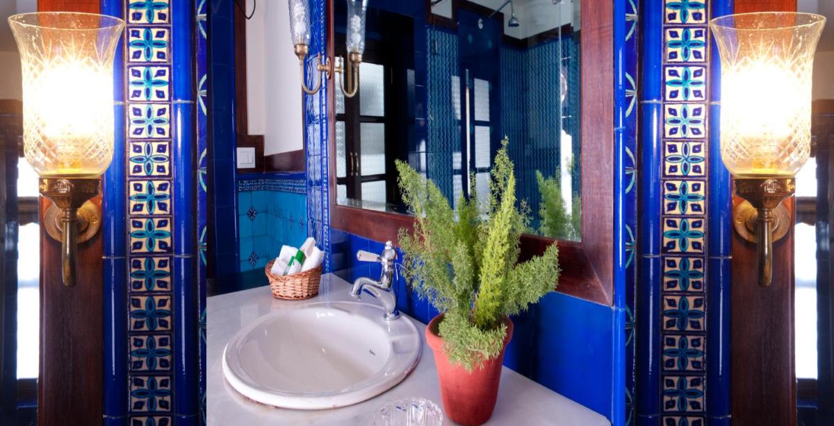 a bathroom with a sink with two lights and a plant at Royal Heritage Haveli - By Leisure Hotels in Jaipur