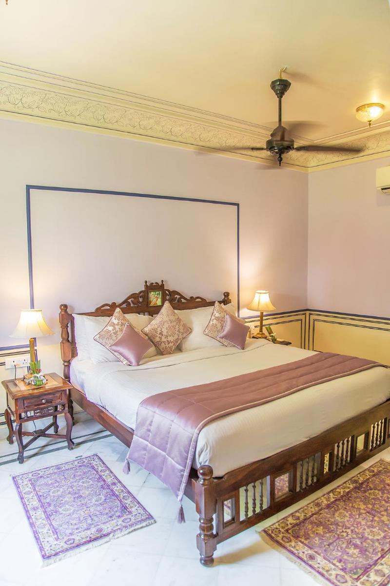 a bedroom with a large bed and two rugs at Royal Heritage Haveli - By Leisure Hotels in Jaipur