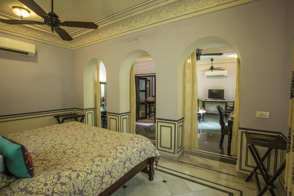 a bedroom with a bed and a living room at Royal Heritage Haveli - By Leisure Hotels in Jaipur