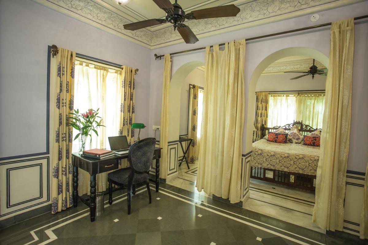 a bedroom with a bed and a desk with a computer at Royal Heritage Haveli - By Leisure Hotels in Jaipur