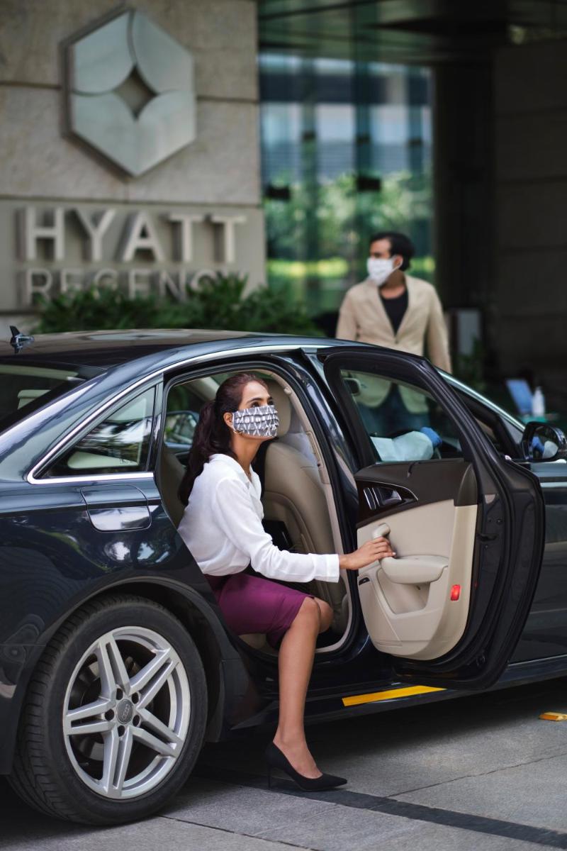 a woman sitting in a car wearing a mask at Hyatt Regency Chandigarh in Chandīgarh