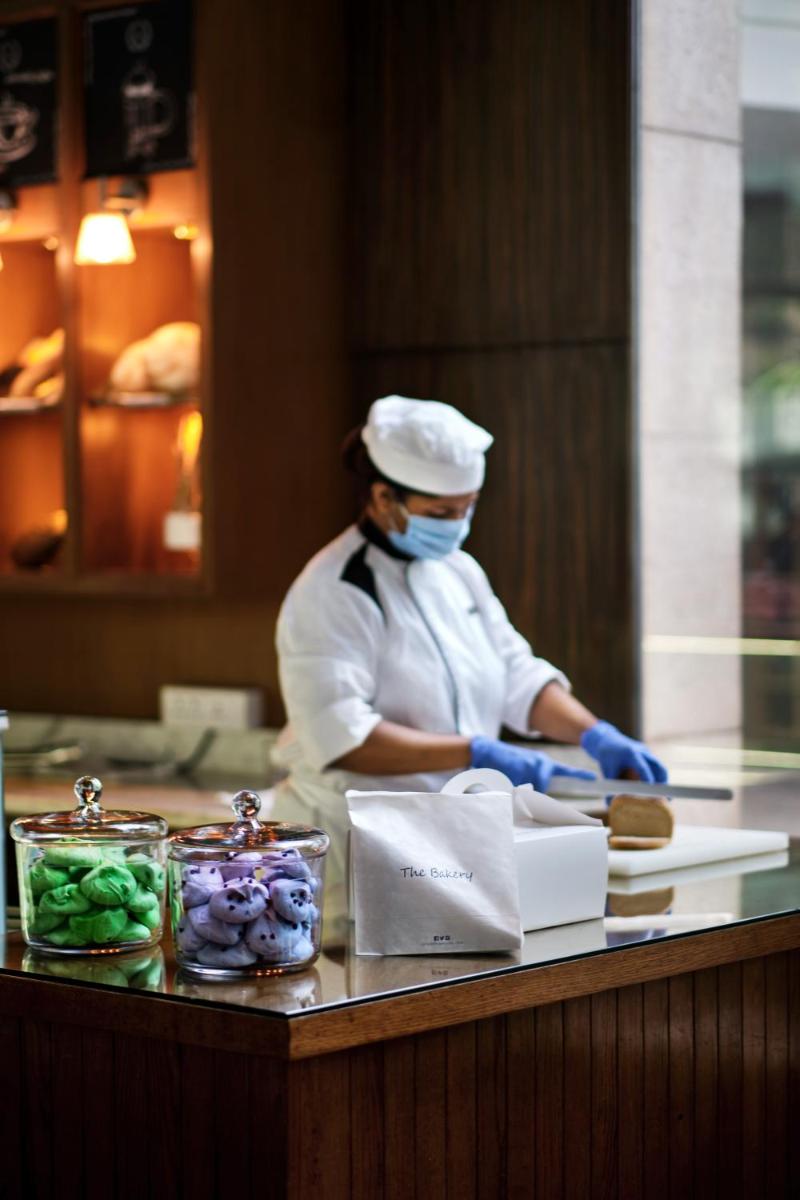 a chef wearing a face mask preparing food in a kitchen at Hyatt Regency Chandigarh in Chandīgarh