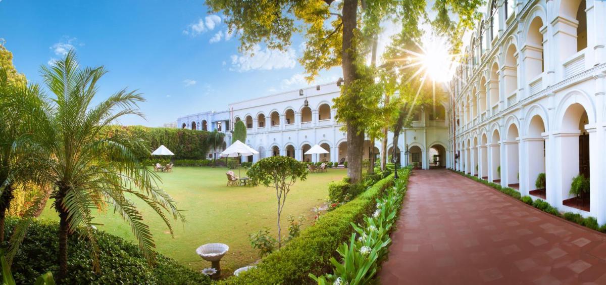 a courtyard of a building with a lawn and trees at The Grand Imperial - Heritage Hotel in Agra