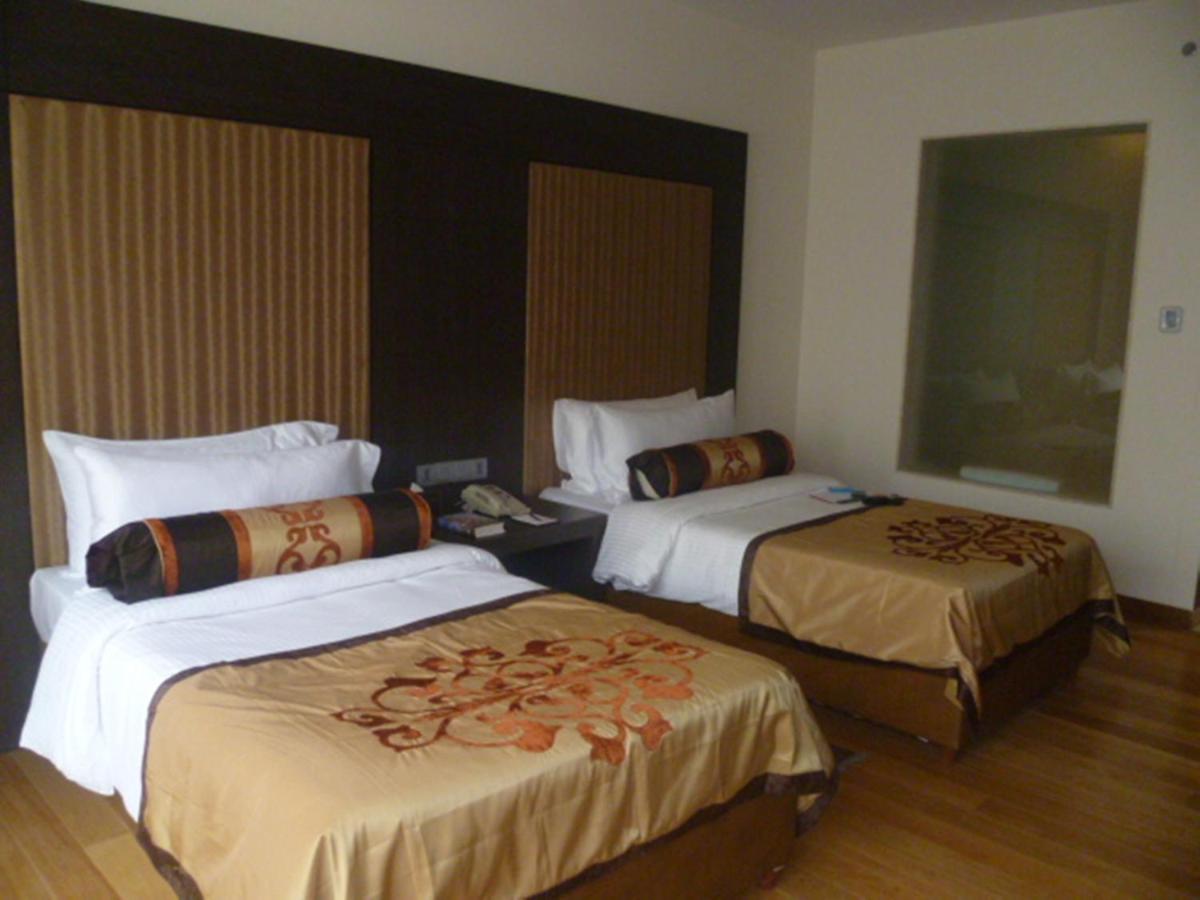 a hotel room with two beds in a room at The Lalit Great Eastern Kolkata in Kolkata a hotel room with two beds in a room at The Lalit Great Eastern Kolkata in Kolkata