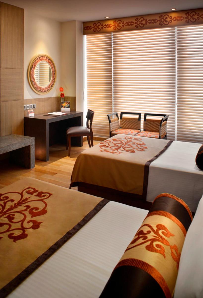 a hotel room with two beds and a desk at The Lalit Great Eastern Kolkata in Kolkata a hotel room with two beds and a desk at The Lalit Great Eastern Kolkata in Kolkata