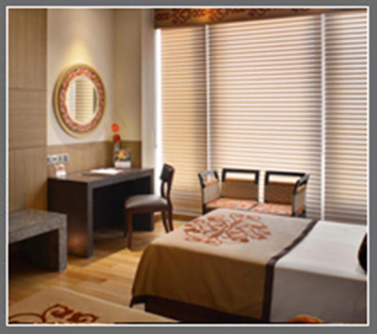 a bedroom with a bed and a desk and a window at The Lalit Great Eastern Kolkata in Kolkata a bedroom with a bed and a desk and a window at The Lalit Great Eastern Kolkata in Kolkata