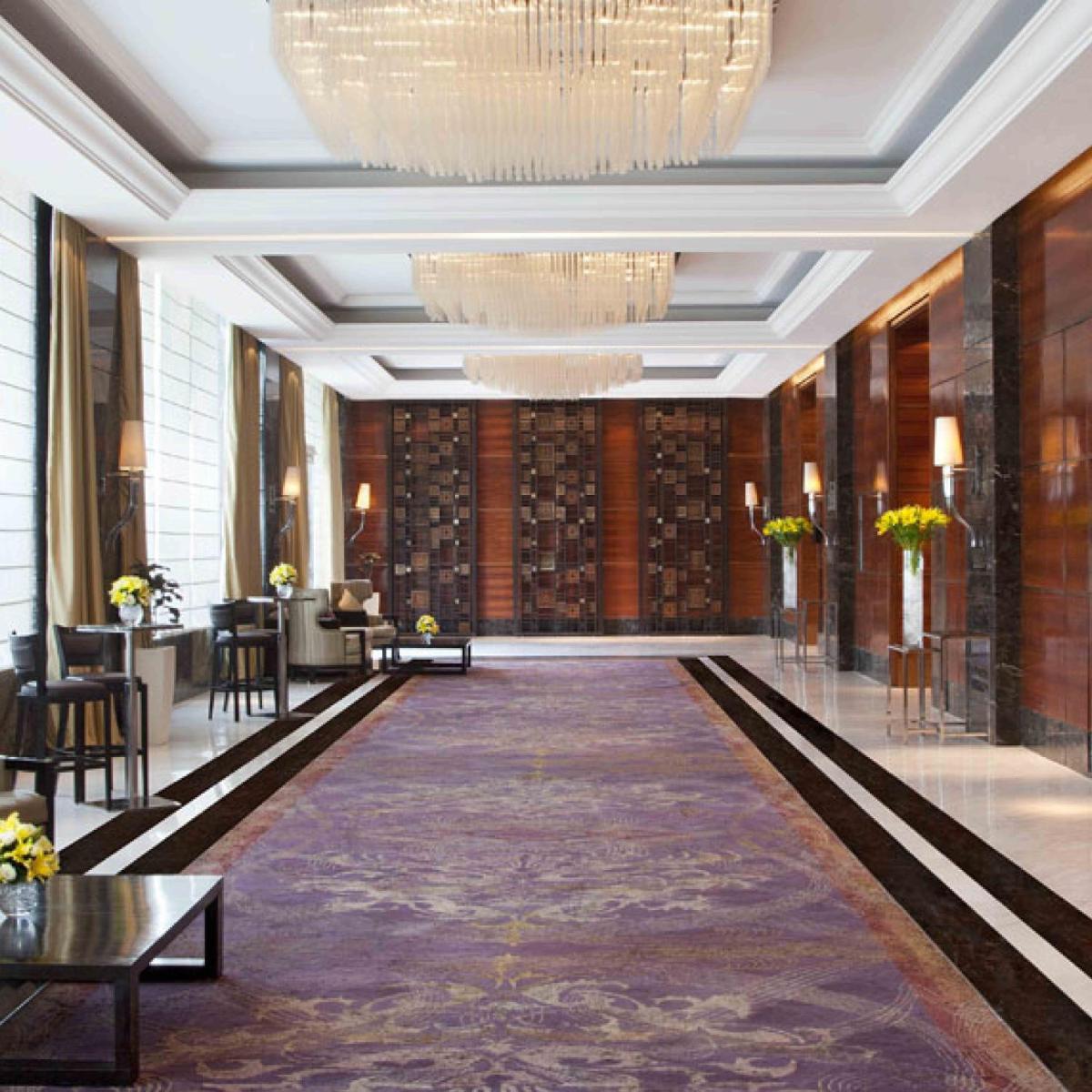 a large lobby with a large hallway with a chandelier at Holiday Inn New Delhi Mayur Vihar Noida by IHG in New Delhi a large lobby with a large hallway with a chandelier at Holiday Inn New Delhi Mayur Vihar Noida by IHG in New Delhi