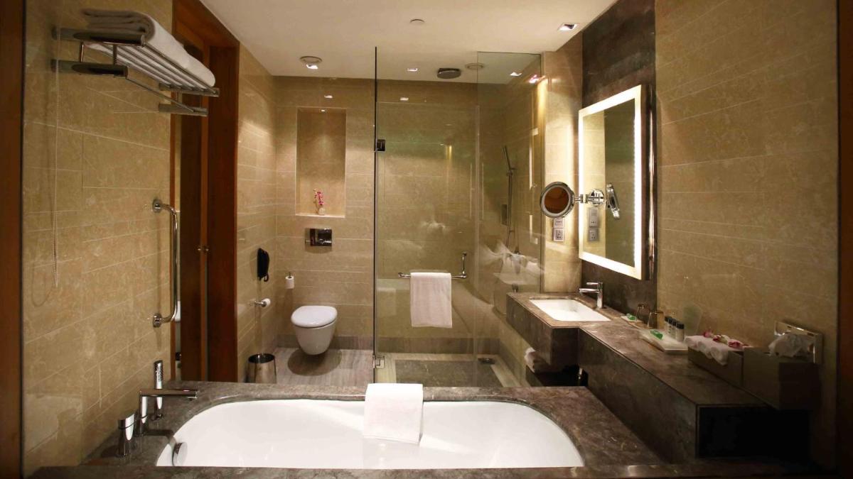 a bathroom with a tub and a toilet and a sink at Holiday Inn New Delhi Mayur Vihar Noida by IHG in New Delhi a bathroom with a tub and a toilet and a sink at Holiday Inn New Delhi Mayur Vihar Noida by IHG in New Delhi