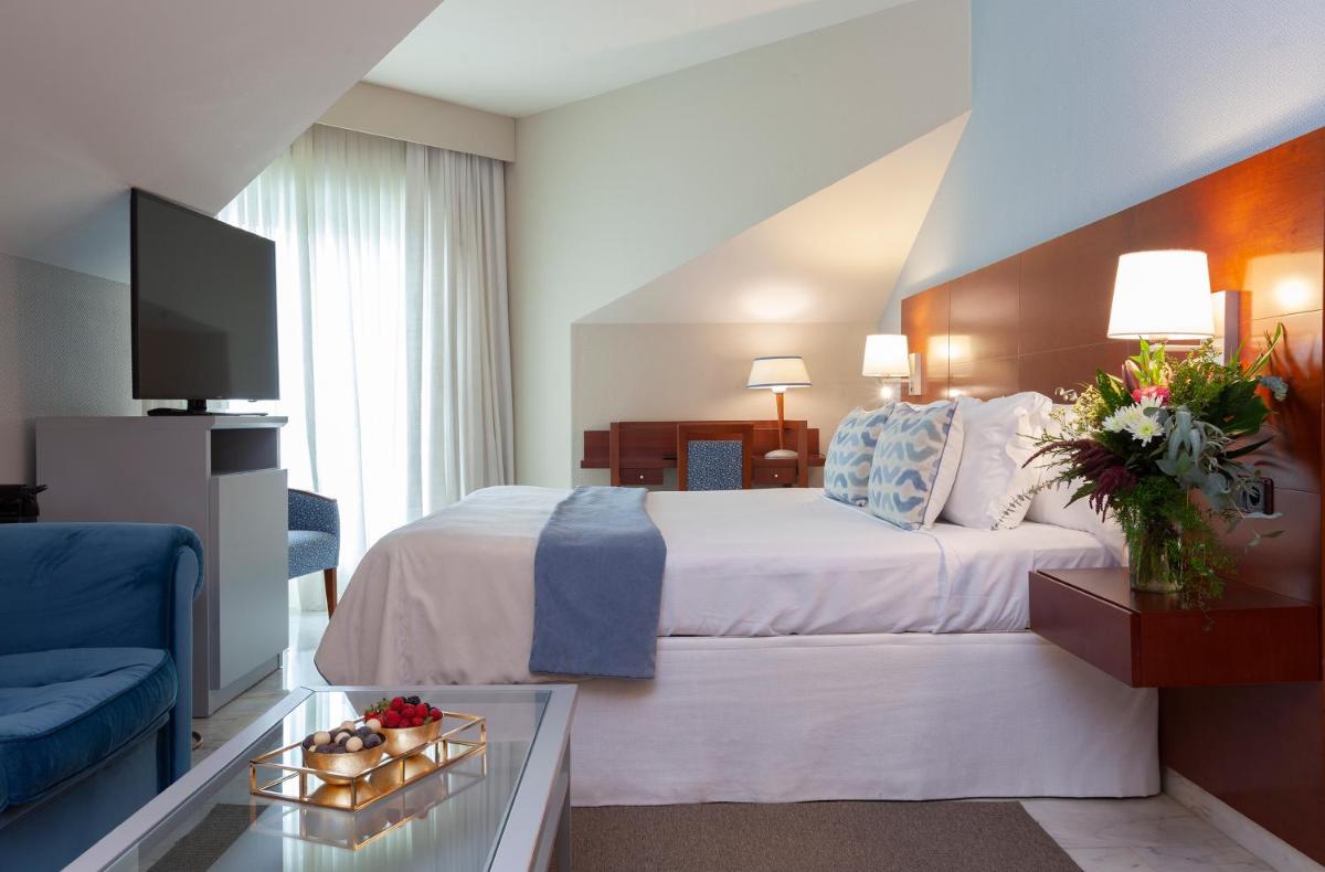 Una habitación de hotel con una cama y un televisor. en Hotel Carlos I Silgar, en Sanxenxo