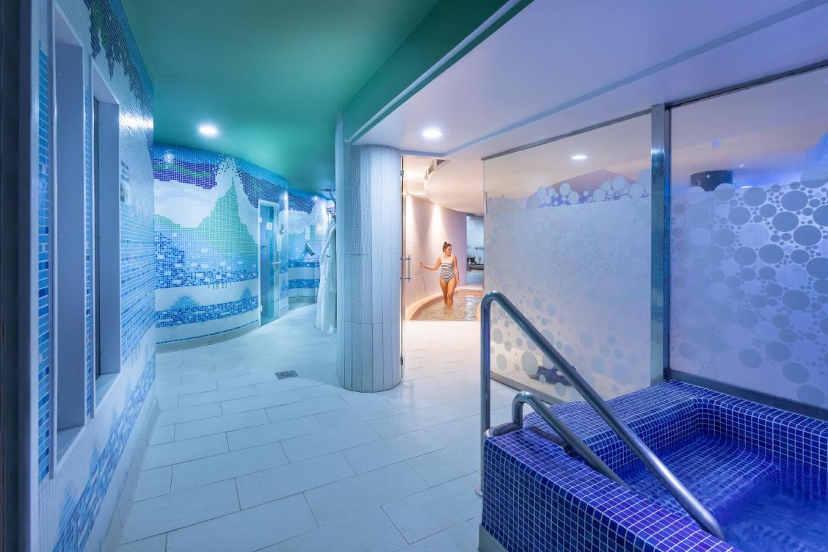 Un baño con paredes azules y blancas y una visera azul. en MUR Faro Jandia Fuerteventura & Spa, en Morro del Jable