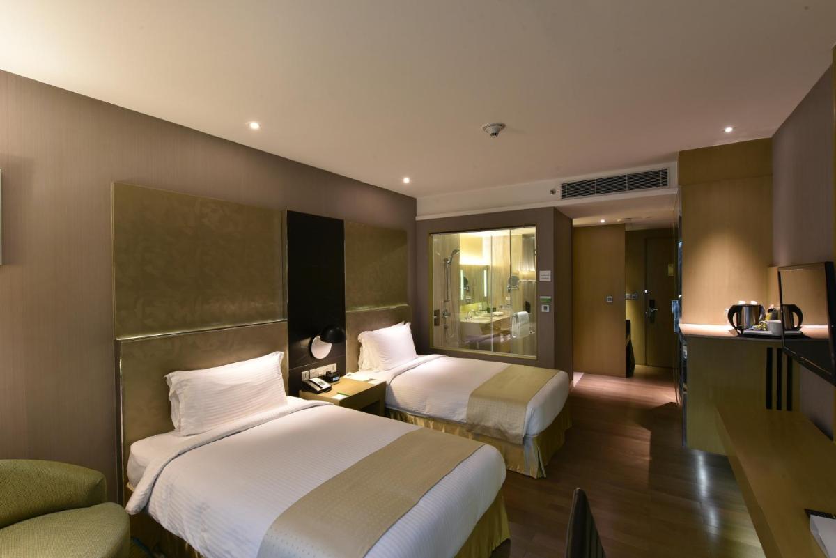 a hotel room with two beds and a couch at Holiday Inn New Delhi Aerocity by IHG in New Delhi
