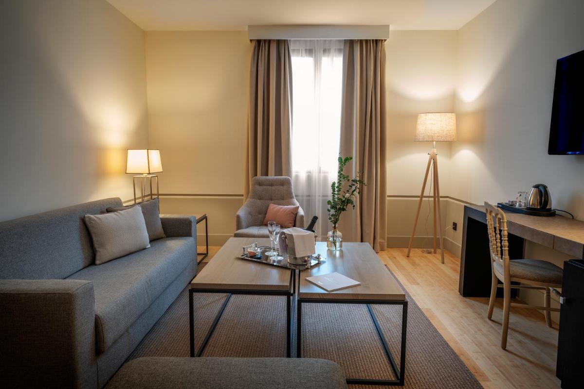 una sala de estar con un sofá y una mesa en Hospes Palacio de Arenales & Spa, en Cáceres