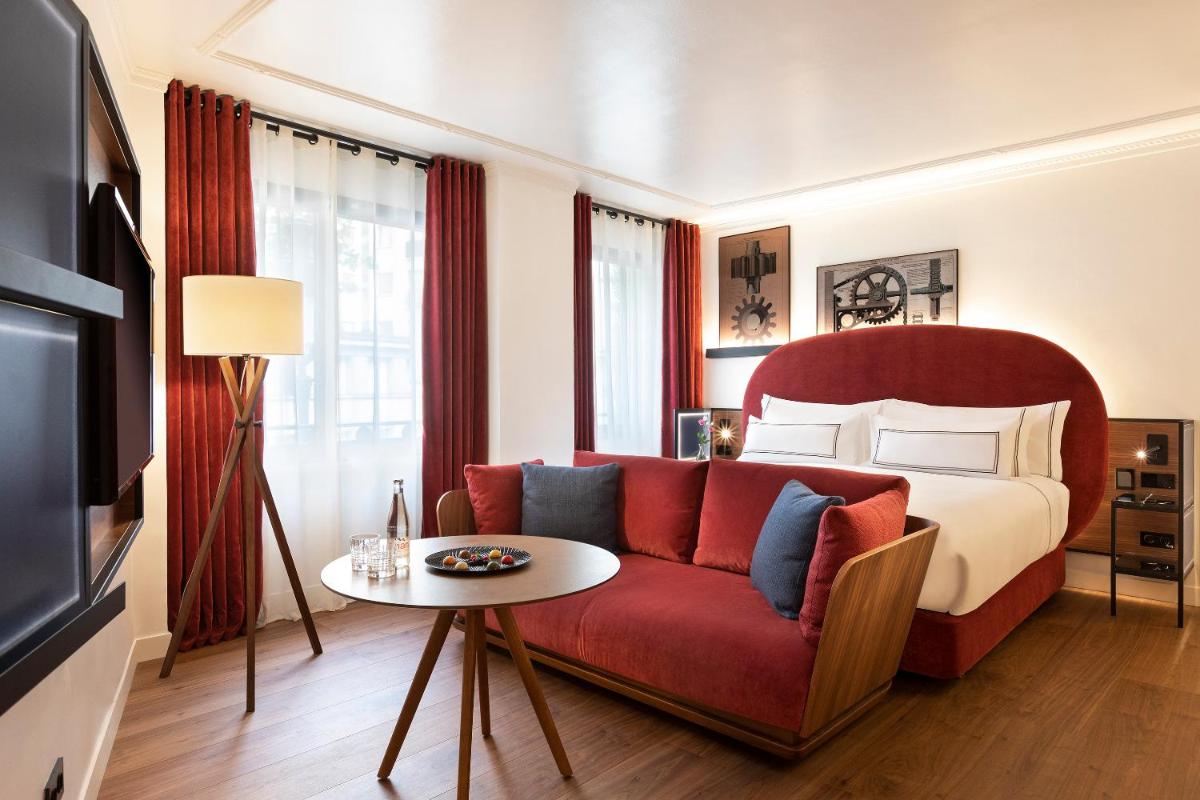 - un salon avec un canapé rouge et un lit dans l'établissement Villa Marquis, member of Meliá Collection - Eiffel Tower, à Paris