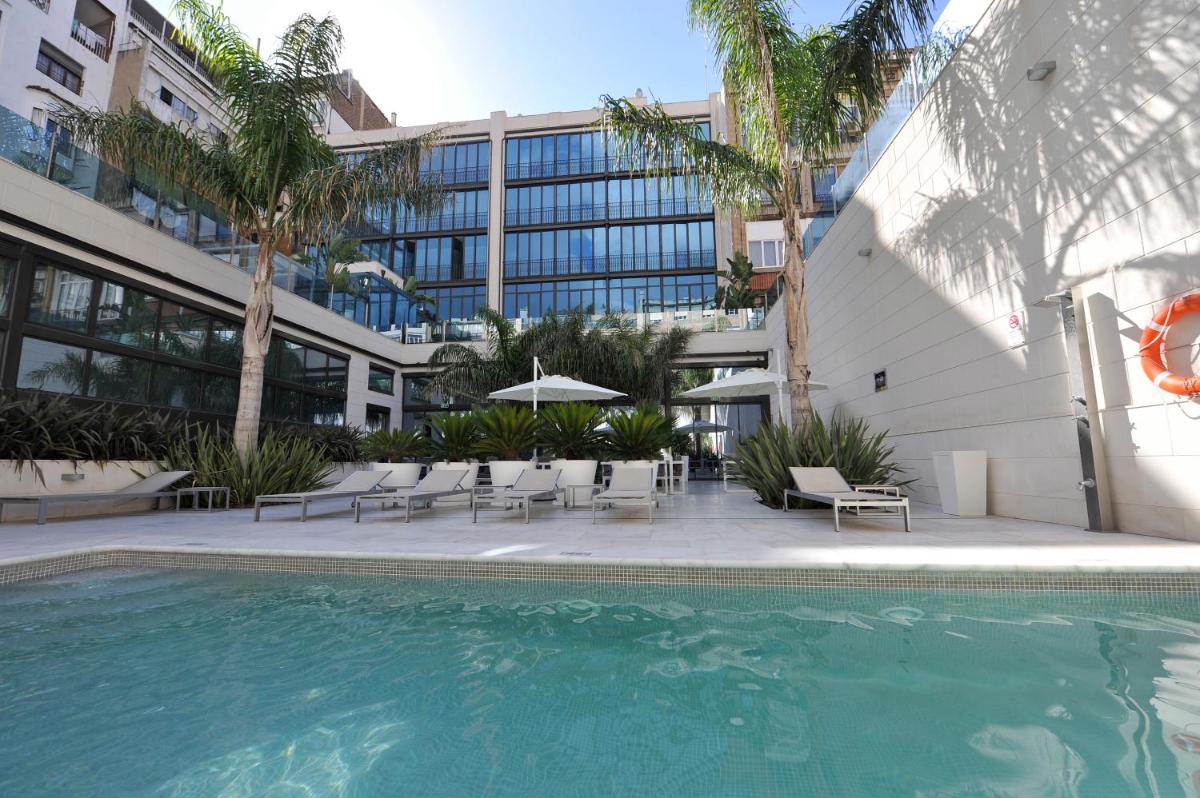 una piscina frente a un edificio con un edificio en Hotel Indigo Barcelona - Plaza Catalunya 4Sup by IHG, en Barcelona